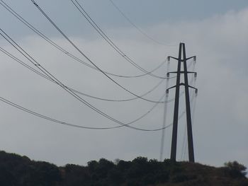 Low angle view of electricity pylon against sky