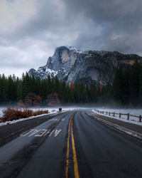 Road amidst trees against sky