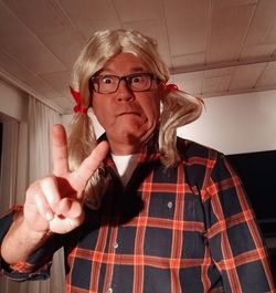 Portrait of man gesturing while making face with wig