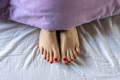 Low section of woman lying on bed