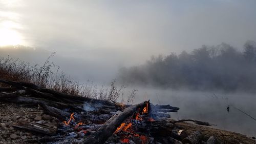 Panoramic view of bonfire in winter against sky