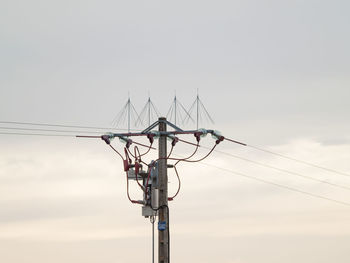 Low angle view of electricity pylon against sky