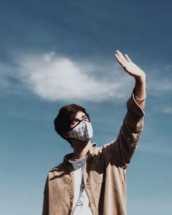 Low angle view of woman standing against sky
