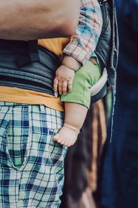 Midsection of father carrying baby