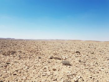 Scenic view of desert against clear blue sky