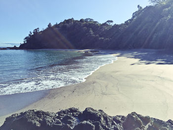 View of calm beach against mountain range