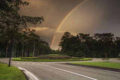 Scenic view of rainbow over trees against sky