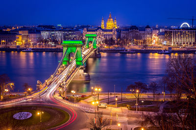 Illuminated golden gate bridge over river in city at night