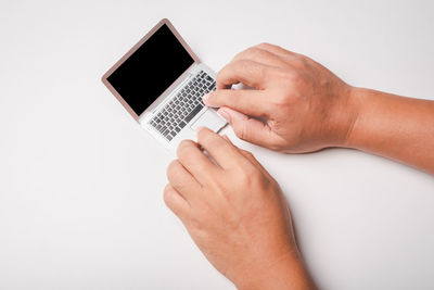 Close-up of man using smart phone against white background