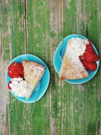 Directly above shot of cake slice with cream and strawberries