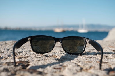 Close-up of sunglasses on beach