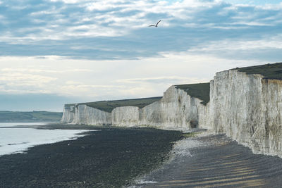 Scenic view of rock formation at beach against sky