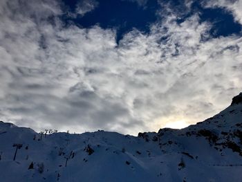 Low angle view of snowcapped mountains against sky