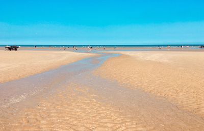 Scenic view of beach against clear blue sky