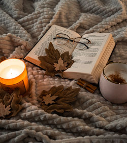 Christmas decorations with lights, hot drink, fruits and a good book