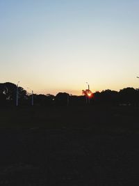 Silhouette city against clear sky during sunset