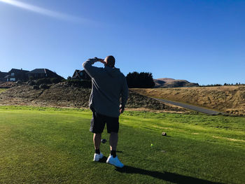 Rear view of a man standing on a golf course