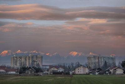 Buildings in city against sky at sunset