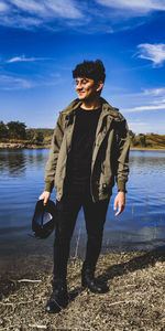 Full length of man standing by lake against sky