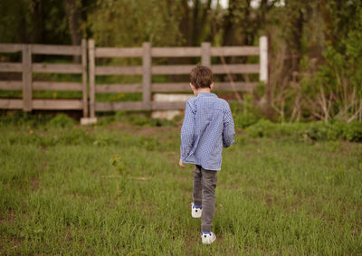 Rear view of boy standing on field