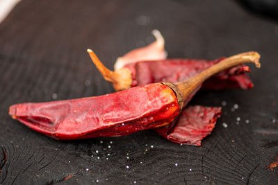 Hot chili peppers on a wooden rustic black board in a street food market, close up