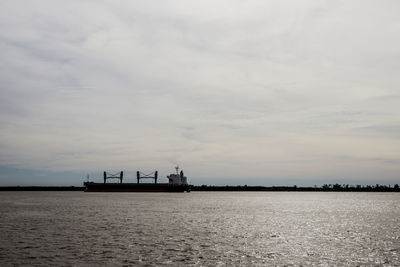 Silhouette boats in sea against sky