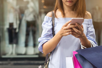 Midsection of woman using mobile phone