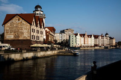 River by buildings in town against sky