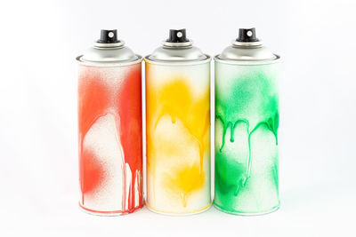 Close-up of multi colored bottles against white background
