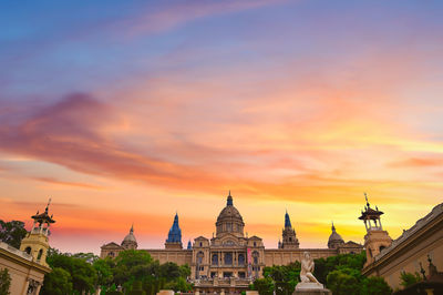 Buildings in city against sky during sunset