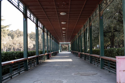 View of empty corridor along bridge and trees