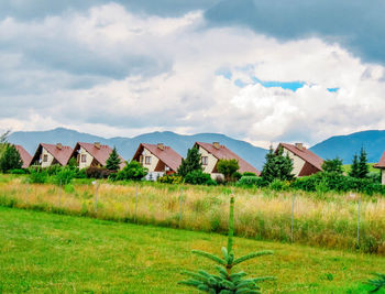 Houses on field against sky