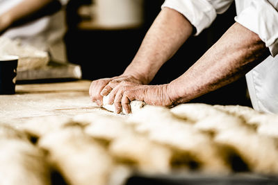 Midsection of man working on cutting board