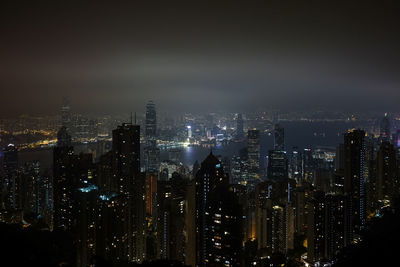 Illuminated cityscape against sky at night