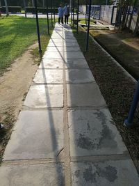 Low section of person walking on footpath in park