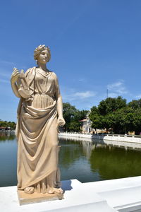 Statue by trees against sky