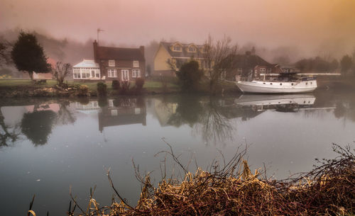 Scenic view of lake by buildings against sky