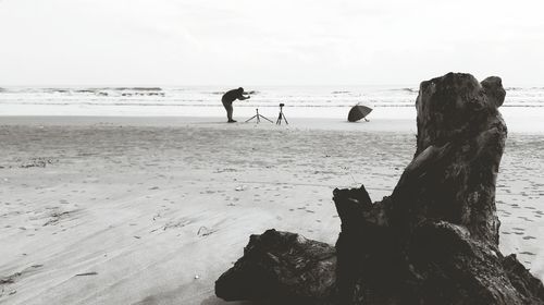 Man with dog on beach against sky