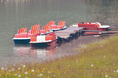 Red boats moored in lake
