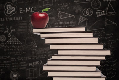 Close-up of apple on stack of books