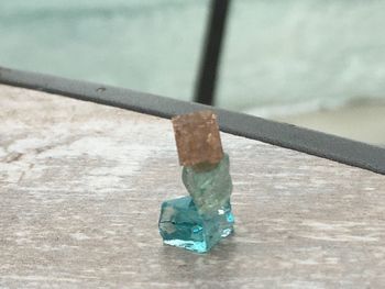 Close-up of chain hanging on railing against wall