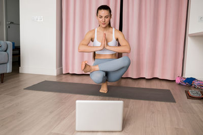 Yoga for increases balance. woman doing half lotus toe balance pose padangustha padma utkatasana 