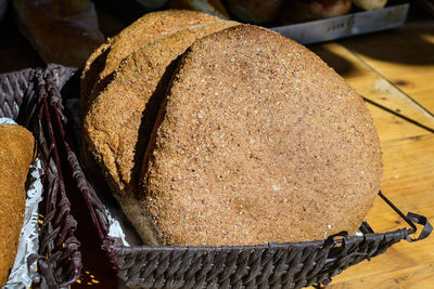 Whole-grain bread displayed for sale in a black plastic baskets at a street food market