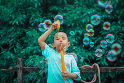 Full length of girl playing with bubbles
