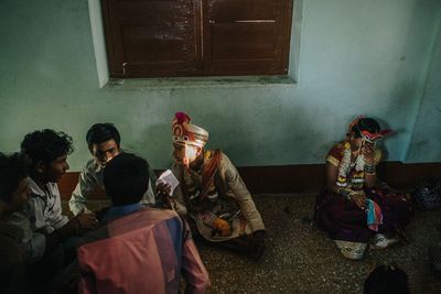 Rear view of people sitting in room