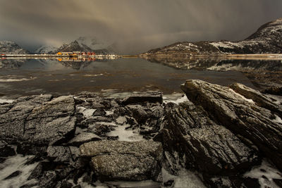 Rock formations by sea against sky during winter