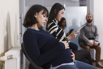 Side view of pregnant woman sitting at office