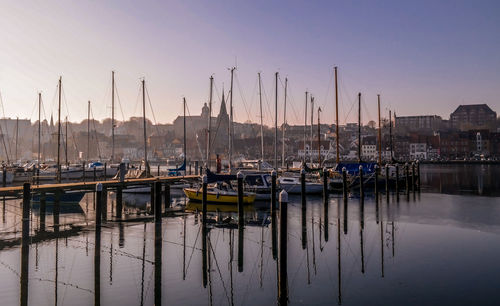 Boats in harbor at sunset