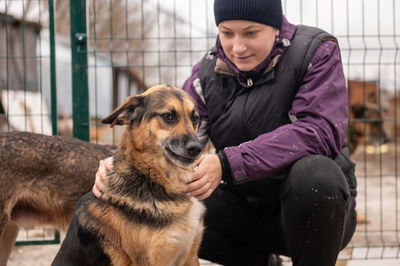 Girl volunteer in the nursery for dogs. shelter for stray dogs.