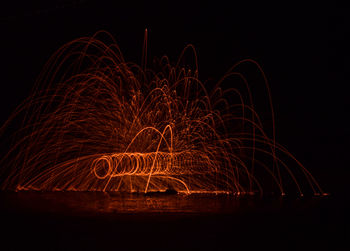 Person spinning wire wool at night